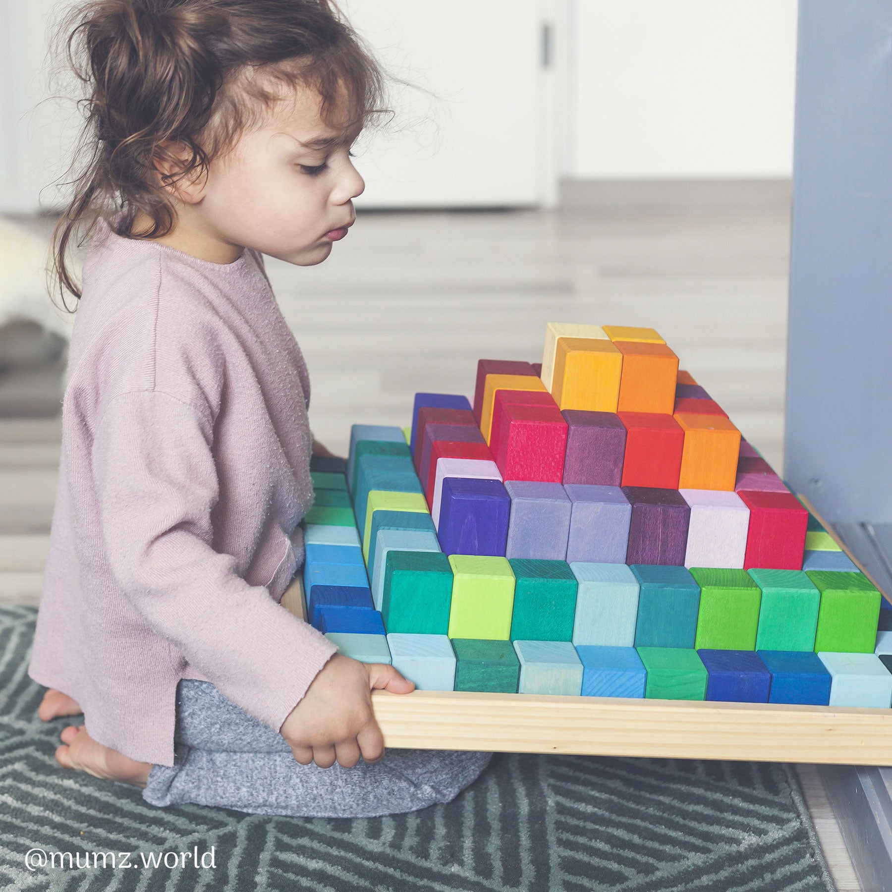 Grimms Large Stepped Pyramid Wooden Toys Photo of toy with a child
