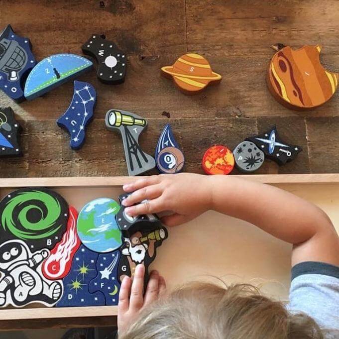 Photo of BeginAgain Space A to Z Puzzle & Playset with child assembling puzzle