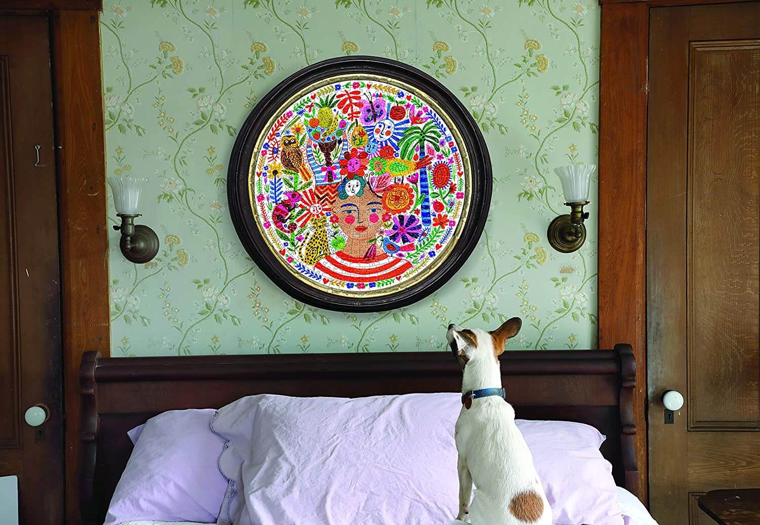 eeBoo - Piece and Love Positivity 500 Piece Round Circle Jigsaw Puzzle photo of completed puzzle in a frame hanging on the wall over a bed with a dog sitting on the bed looking at the puzzle